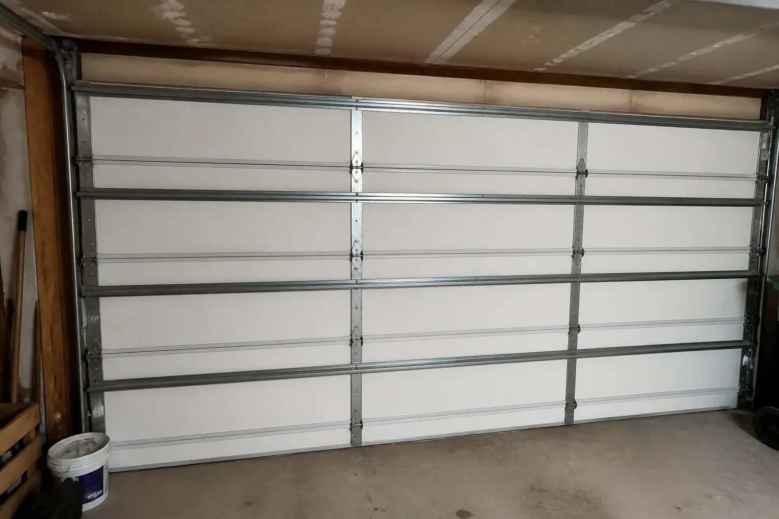 Interior of a closed sectional door with horizontal metal reinforcement struts. — Wind-Rated Garage Door Replacement, Wasaga Beach